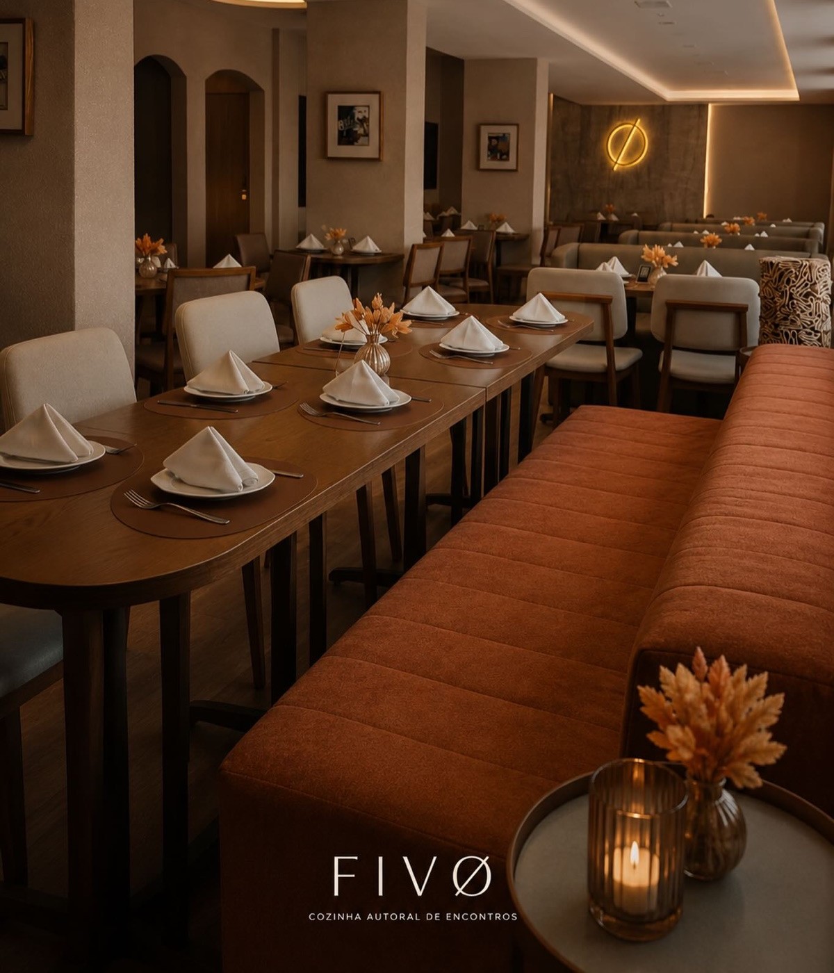 Salão do FivØ Cozinha — luz âmbar, madeira e o Ø em neon na parede